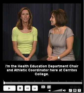 A video still of two ladies sitting in front of a black backdrop with a caption that reads 