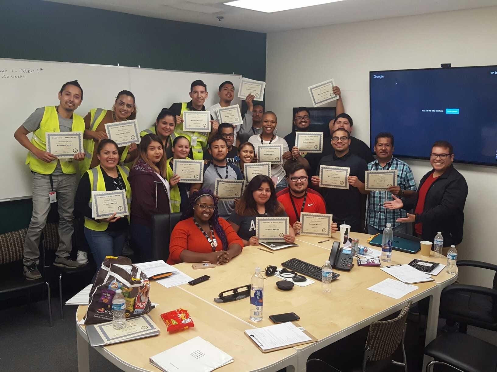 A group of employees at Black Tux with Leadership completion certificates
