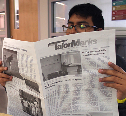 Student reading the Talon Marks newspaper