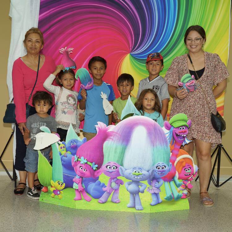 Family in front of Trolls Poster