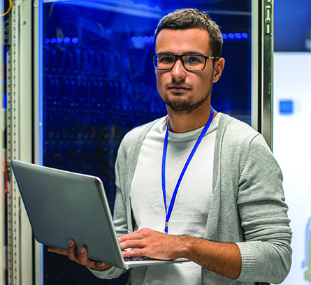 Male student smiling in front of a computer