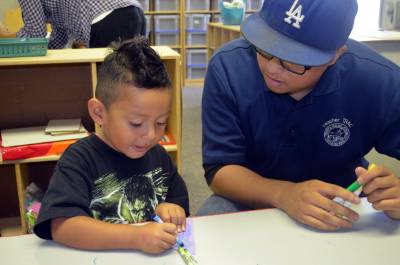 Male TRAC Student working with a child