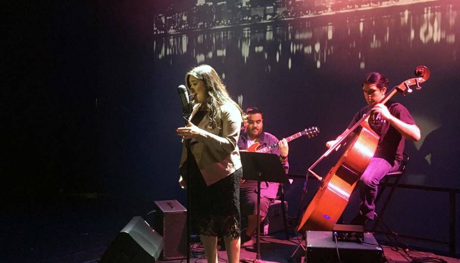 three musicians on stage with soft lighting and background