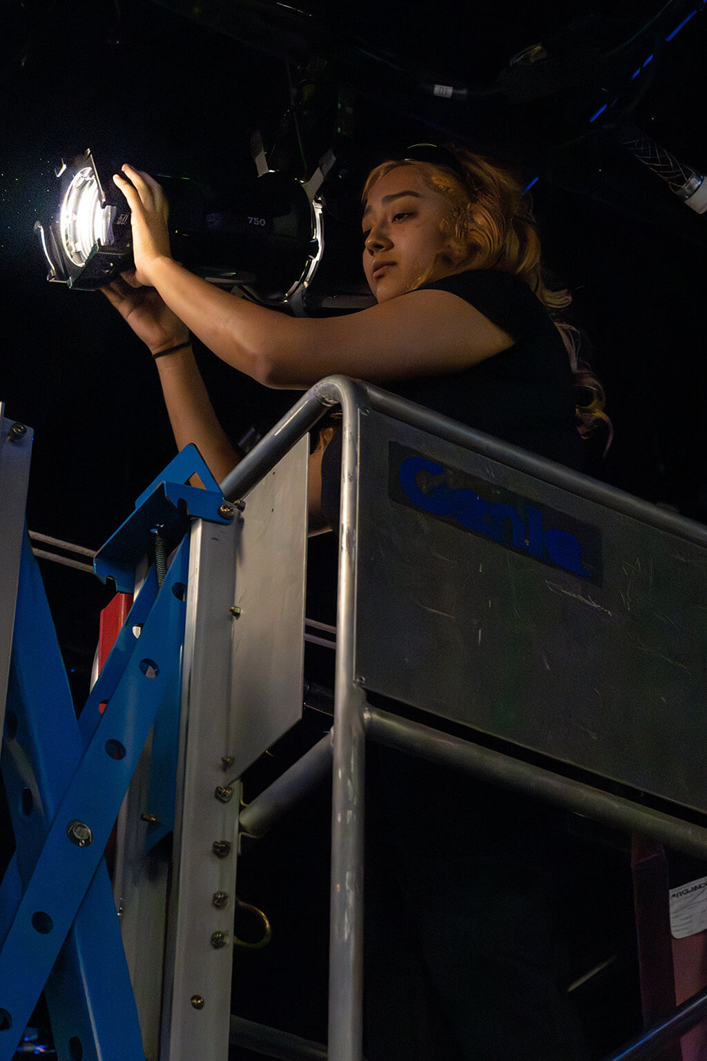 Student adjusting theatre lighting
