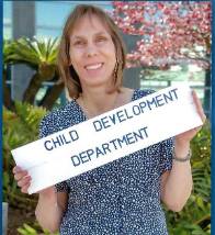 Angie Beck holding a sign that says "Child Development Department"