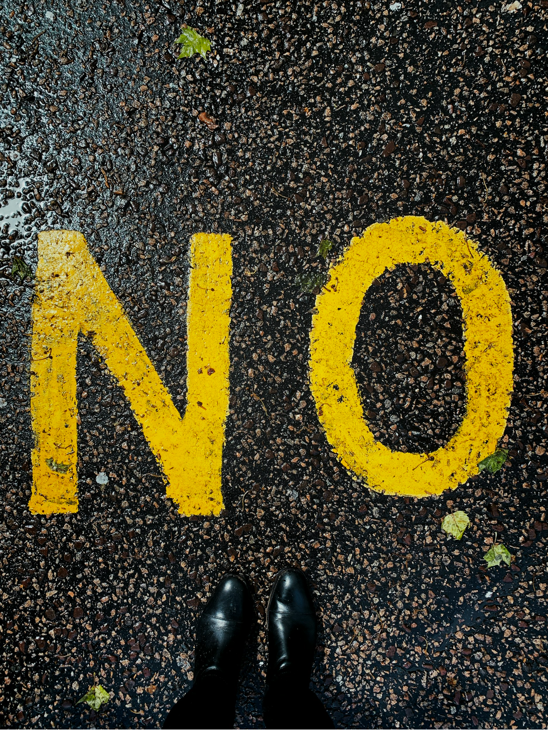 feet in front of word "NO" painted on pavement