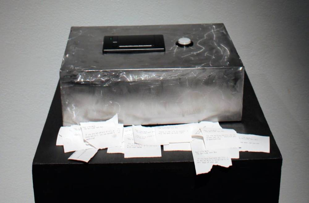 Multiple small pieces of paper in front of metal box.