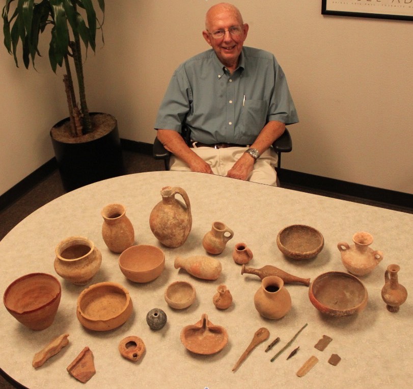Dr. Grindel Poses with artifacts from his donated collection