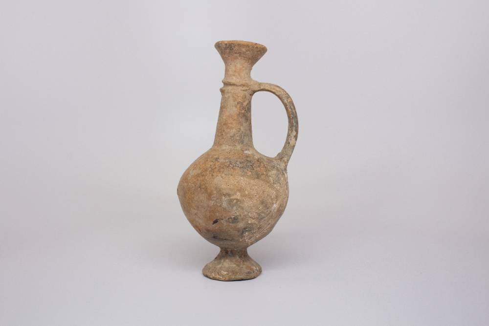 Ceramic jug with long neck and one handle.