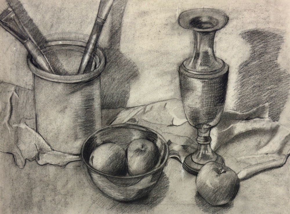 Fruit bowl in center vase to the right brush holder with brushes to the left.