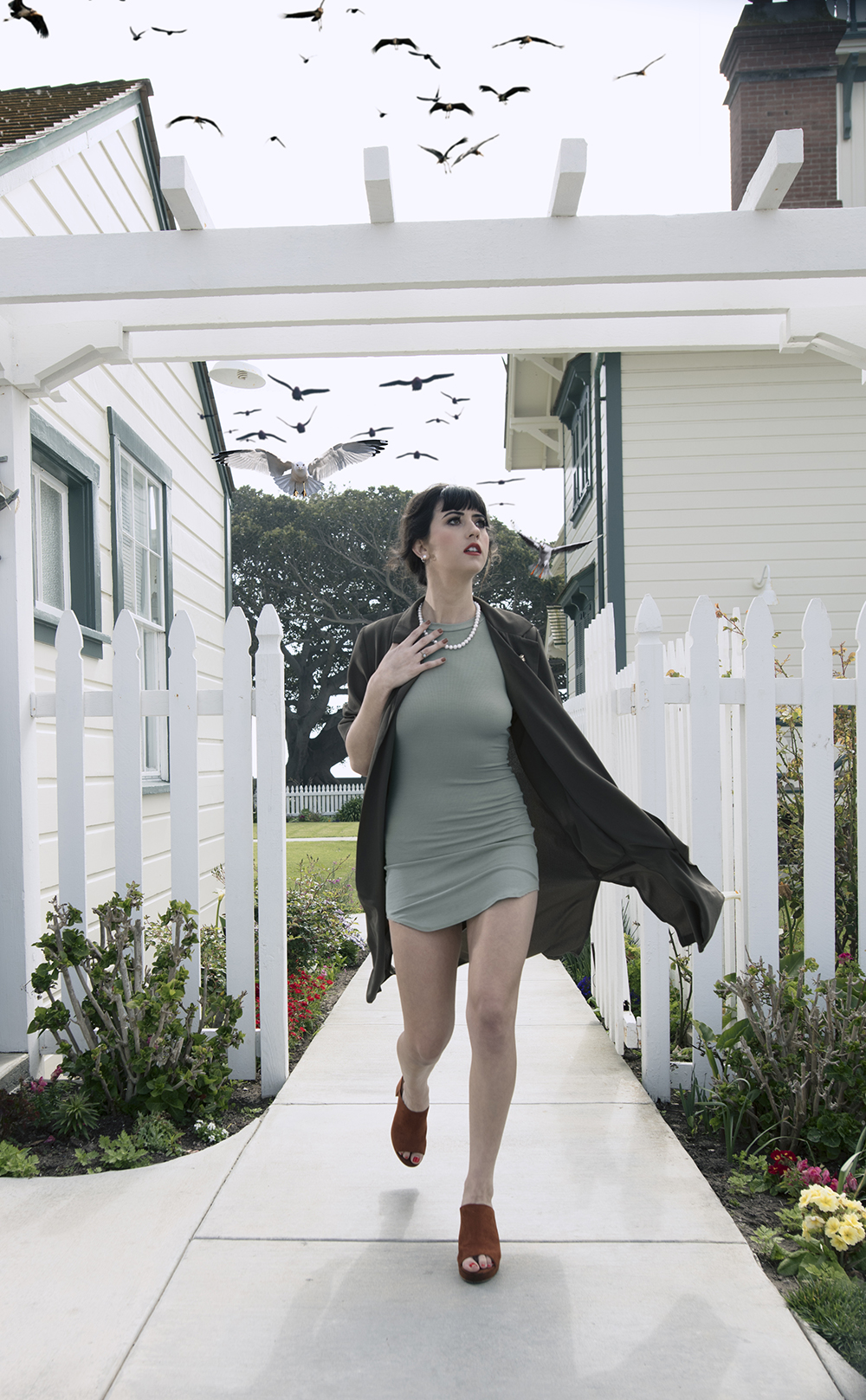 A woman running from a flock of birds
