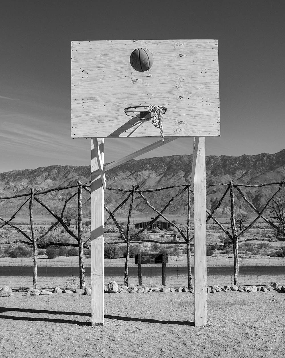 A basketball suspended above an old hoop