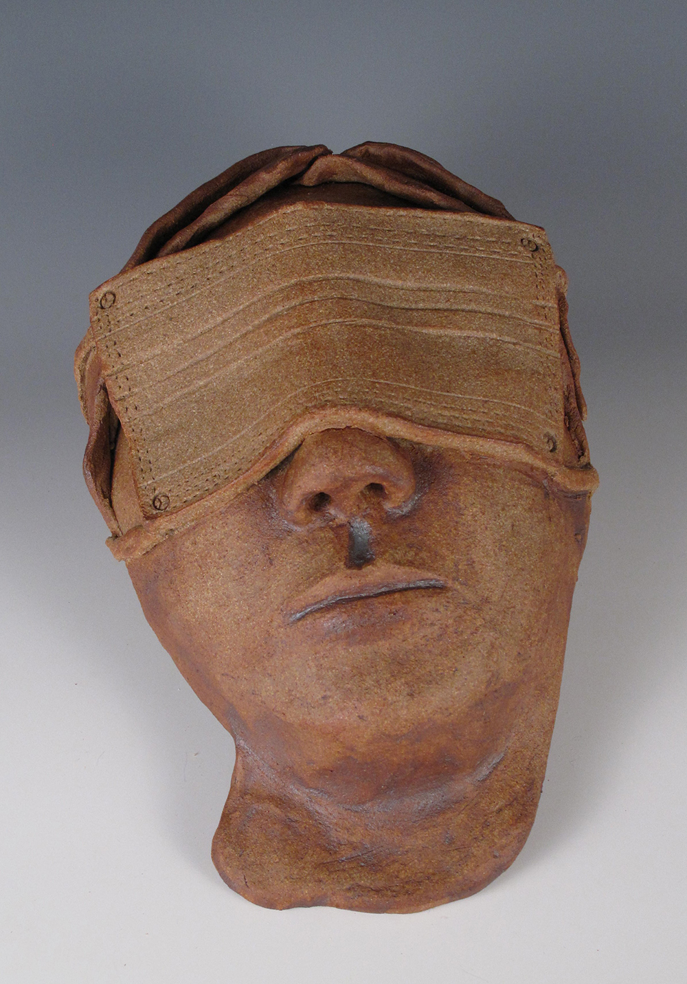 A Ceramic Portrait Wearing a Mask Over the Eyes