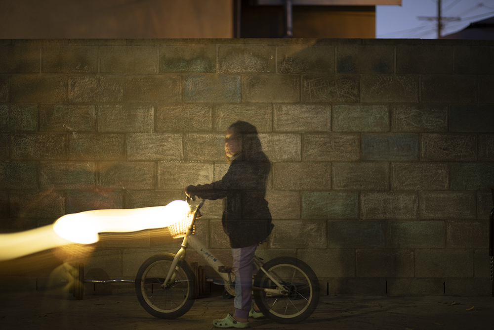 A child pushing a glowing bike