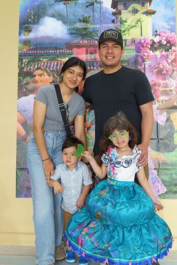 Family in front of Encanto poster