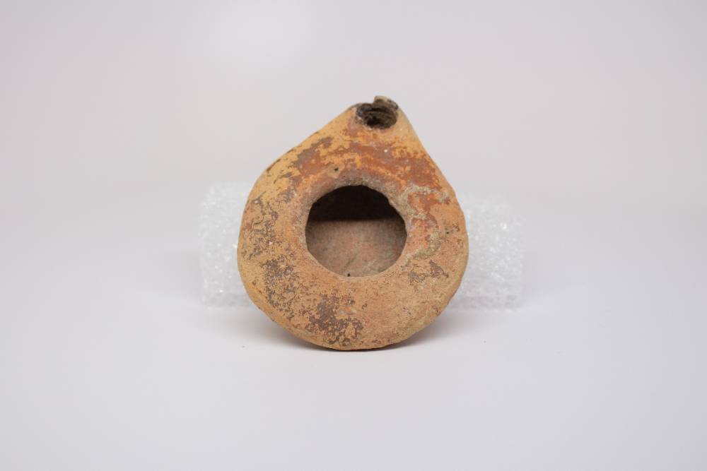 Tear-drop shaped ceramic with a hole in the center and a hole at the point.
