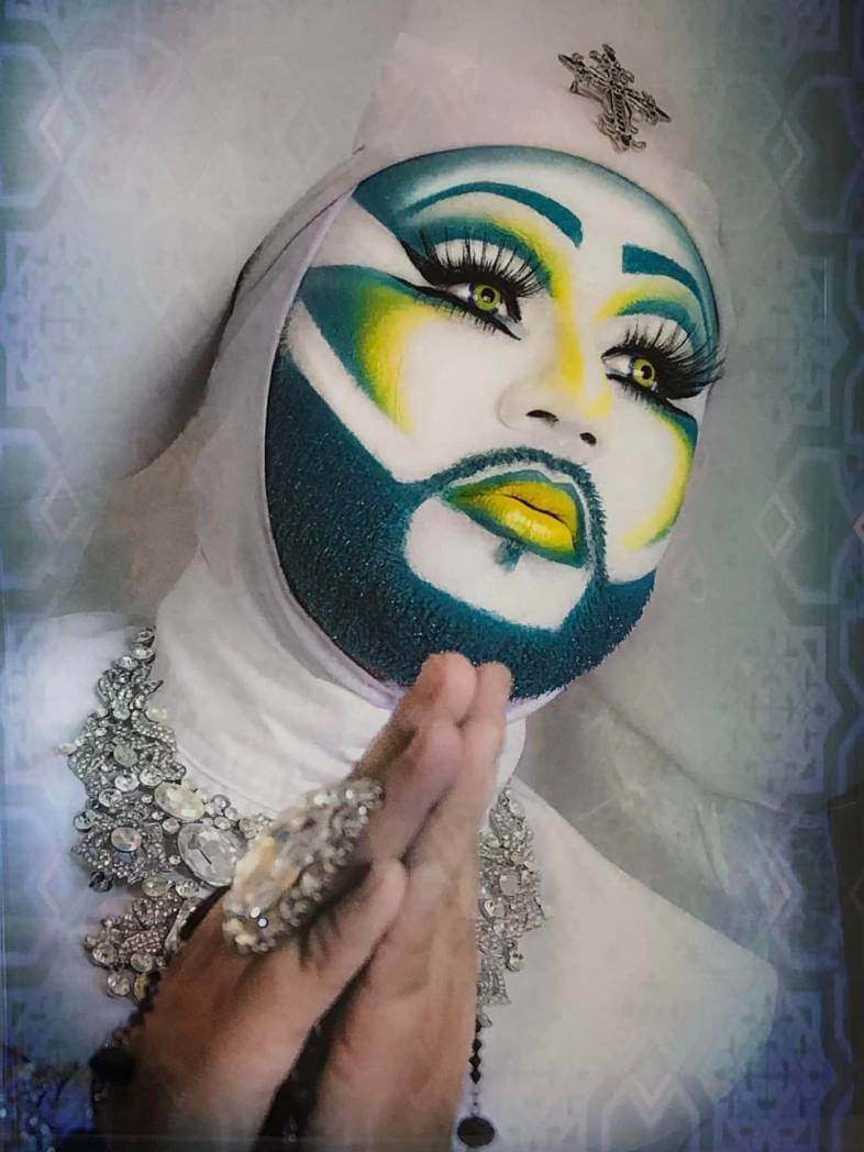 Drag queen in nun costume with prayer hands.