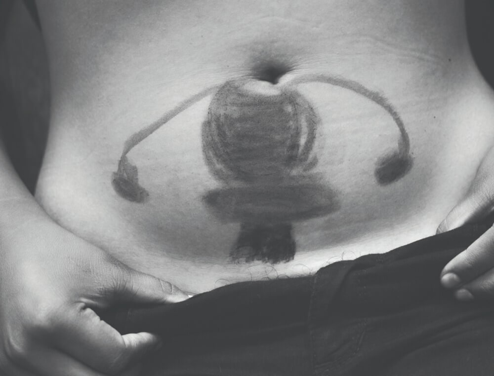 Uterus drawn on lower abdomen area of a woman.