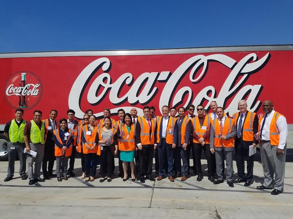 A group of visitors in front of the CocaCola sign