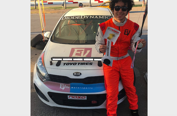 Eli Villa by a race car