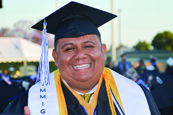 Latinx student in cap and gown