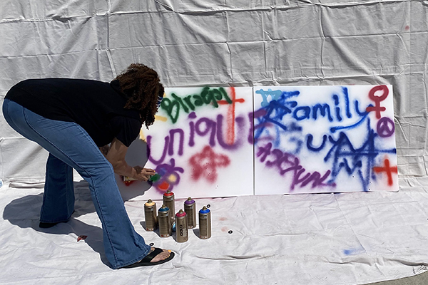 Student spray-painting an art piece