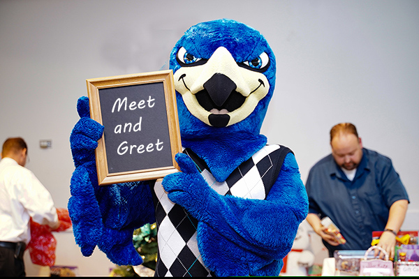 Franco Falcon with a sign reads Meet and Greet