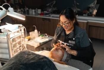 Student performing facial on a client