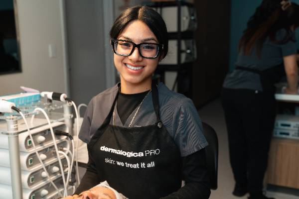 Student posing in an esthetician classroom environment. 