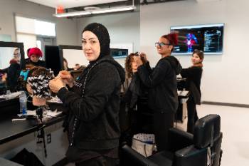 Cosmetology students peforming hairstyle on mannequins