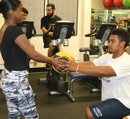 Fiteness Trainer helping a student