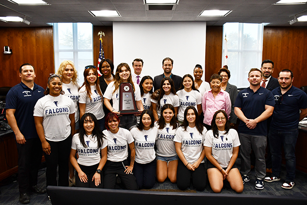 Women's wrestling team with board members