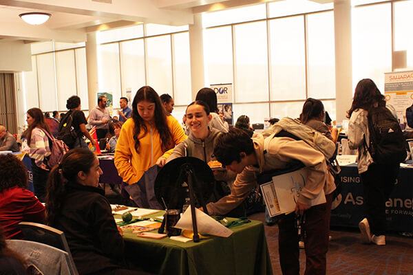 Attendees at a Community Resource Fair booth
