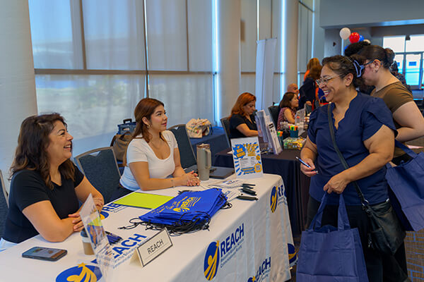 Employers and attendees talking at Job Fair booth