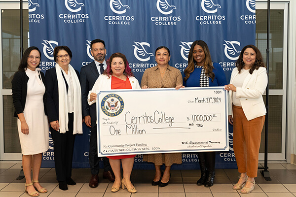 Rep. Linda Sanchez and College officials holding a ceremonial check