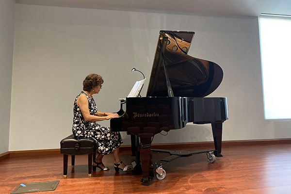 Dr. Christine Lopez playing donated piano