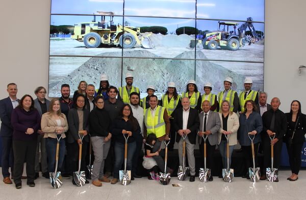 College officials and construction team holding shovels