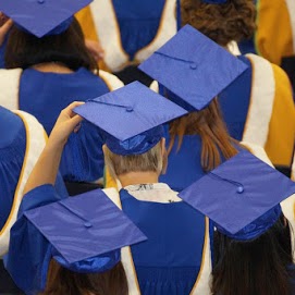 Graduates wearing blue cap and gown listening to a service