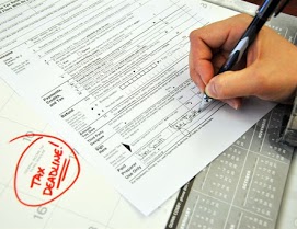 An individual's hands signing an income tax document