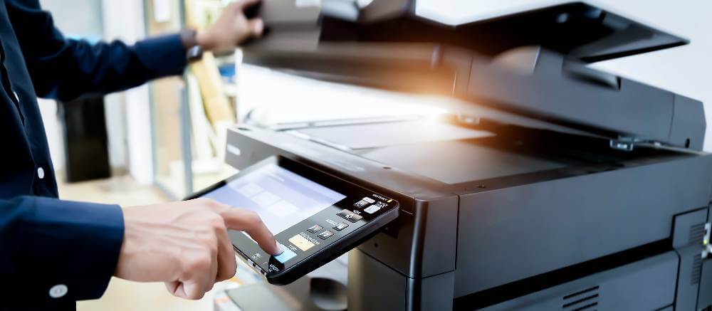 A person interacting with a printer scanner.