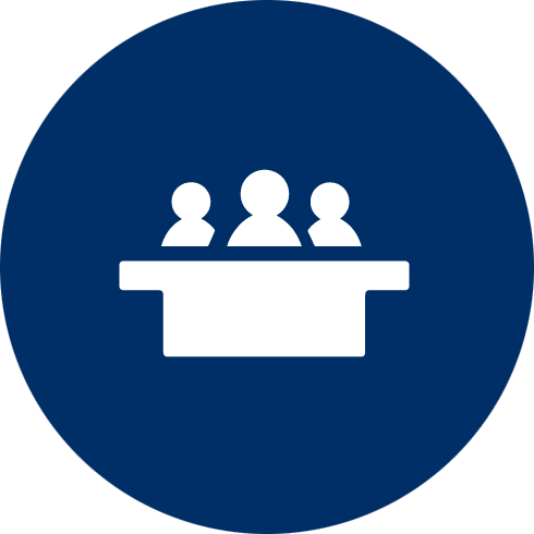 White icon inside a blue circle showing three people sitting at a table across from each other, with conversation and question mark speech bubbles above them.