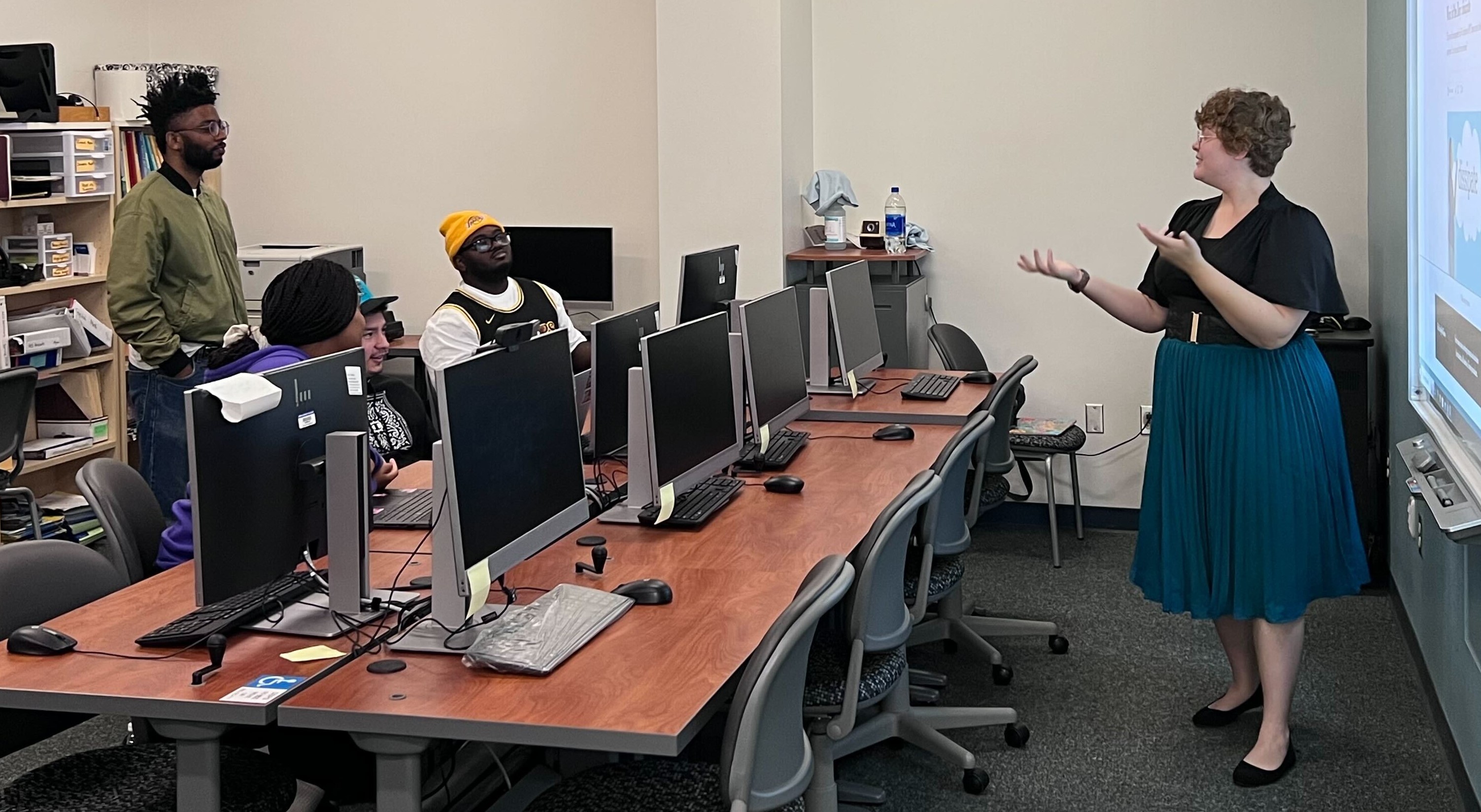 Female instructor signing to class of Deaf students.