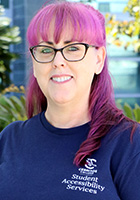 Robin Taylor with pink hair and wearing a blue SAS shirt